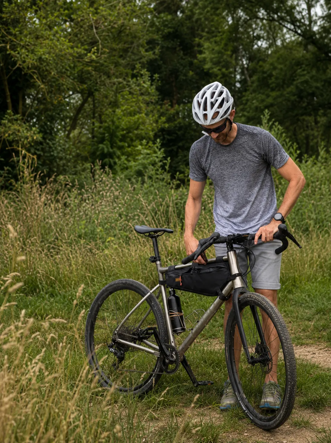 Cycliste avec un vélo gravel équipé de freins à disque dans l'herbe - The Rolling Steph